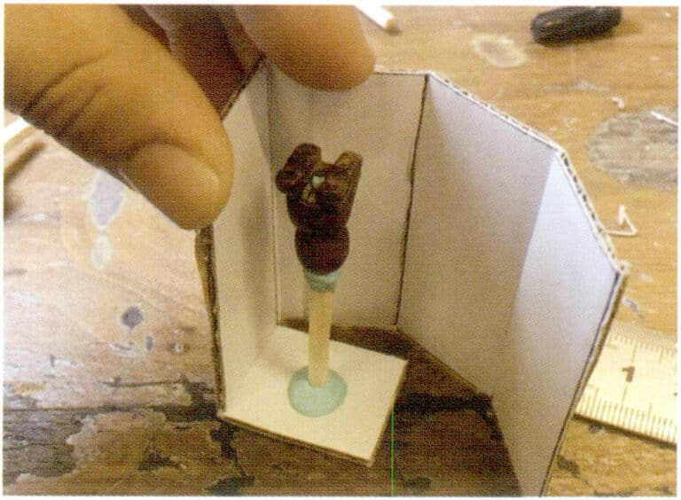 4. Make a casting box of suitable size from stiff cardboard. If the cardboard box is too small, first stick the prepared object's sprue down to the bottom, ensuring it is securely fixed, as liquid silicone has a certain buoyancy. If not securely attached, the item may float up during the pouring process, leading to a failed mold.