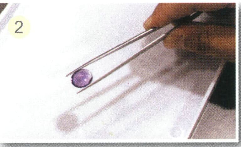 (2) Hold the gemstone, ensuring it does not extend beyond the end of the clamp. Hold the clamp with your hand positioned slightly lower in the middle.