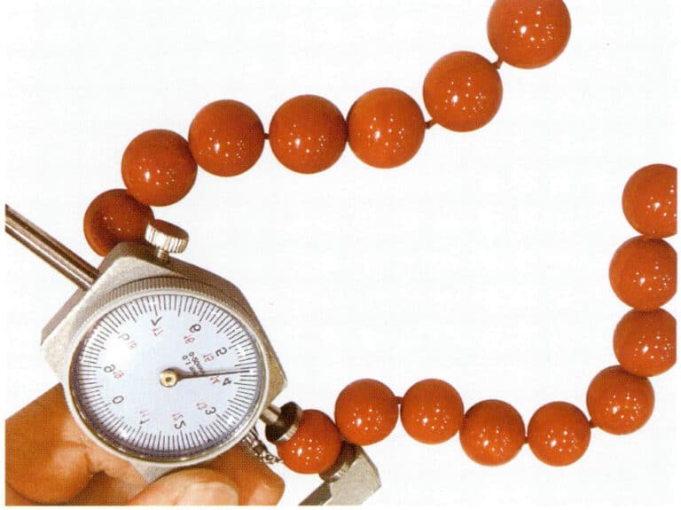 Рисунок 3-7-32 Измерение диаметра коралловых бусин с помощью толщиномера