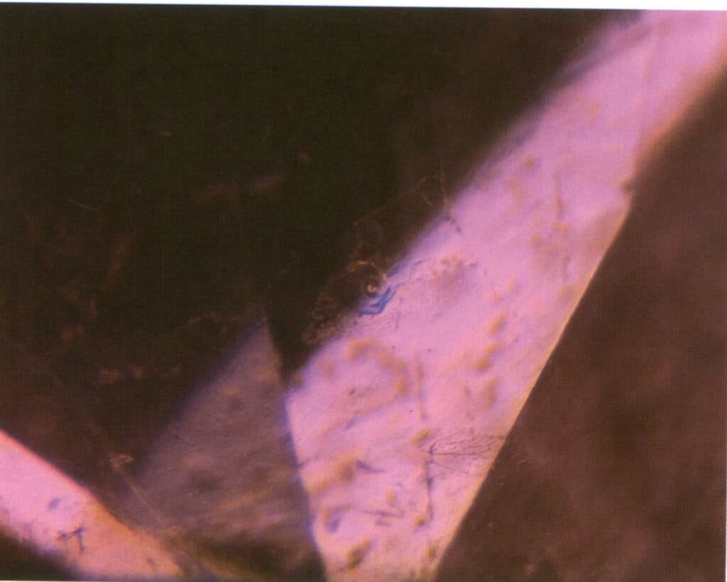 Rysunek 5-1-15 Efekt niebieskiego błysku i bąbelki w szkle szczelin rubinowych (metoda oświetlenia ciemnego pola 20X)