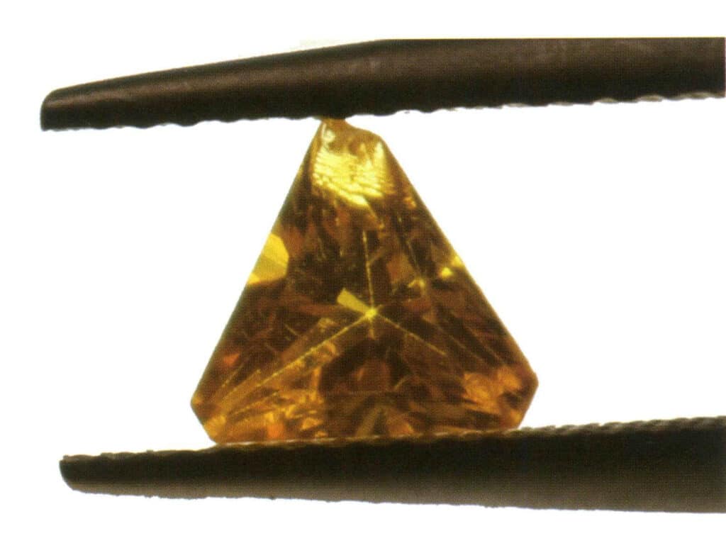 الشكل 2-3-40: شفاف (عقيق الألومنيوم الاصطناعي النحاسي النحاسي، الضوء المنقول). إن النقطة الأساسية للحكم على شفافية الأحجار الكريمة ذات معامل الانكسار العالي مثل الألماس هي القدرة على رؤية الأوجه والأسطح على الجانب الآخر من الحجر الكريم.