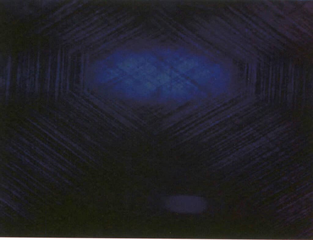 الشكل 2-3-67 ثلاث مجموعات من الشوائب المتوازية الكثيفة الاتجاهات في الياقوت الأزرق النجمي (30×، طريقة إضاءة الحقل المظلم)