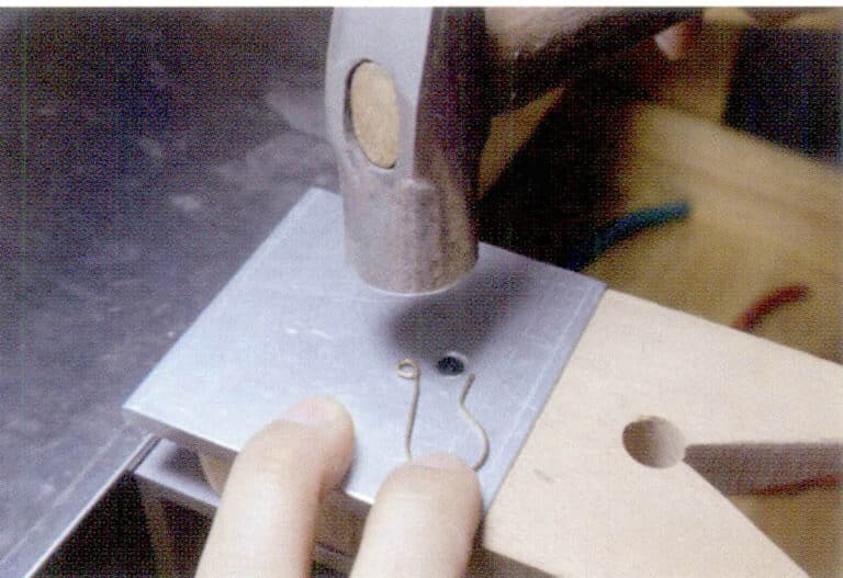 3. С помощью плоскогубцев отрегулируйте форму ушного крючка, а затем с помощью молотка доработайте плоскость ушного крючка.