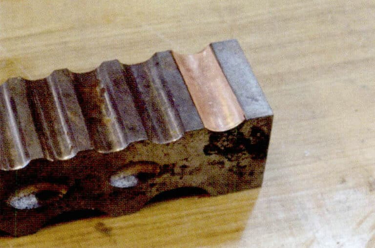 2. Молоток ударяет по пуансону, вызывая вмятину на металлическом листе.