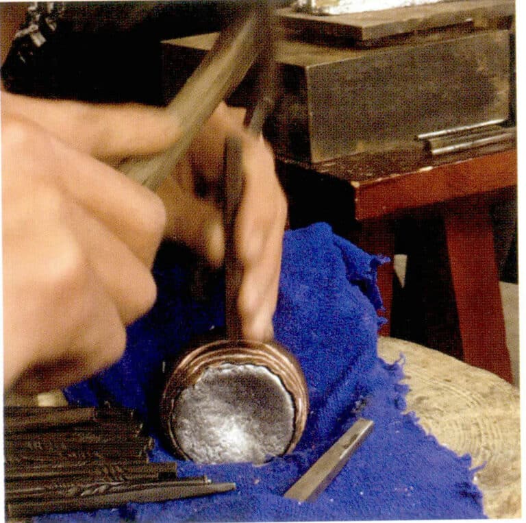 Hammering the uneven texture with a hammer and chisel