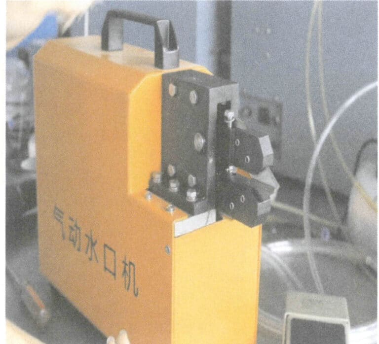 Figura 8-13 Taglio della materozza con una crimpatrice pneumatica