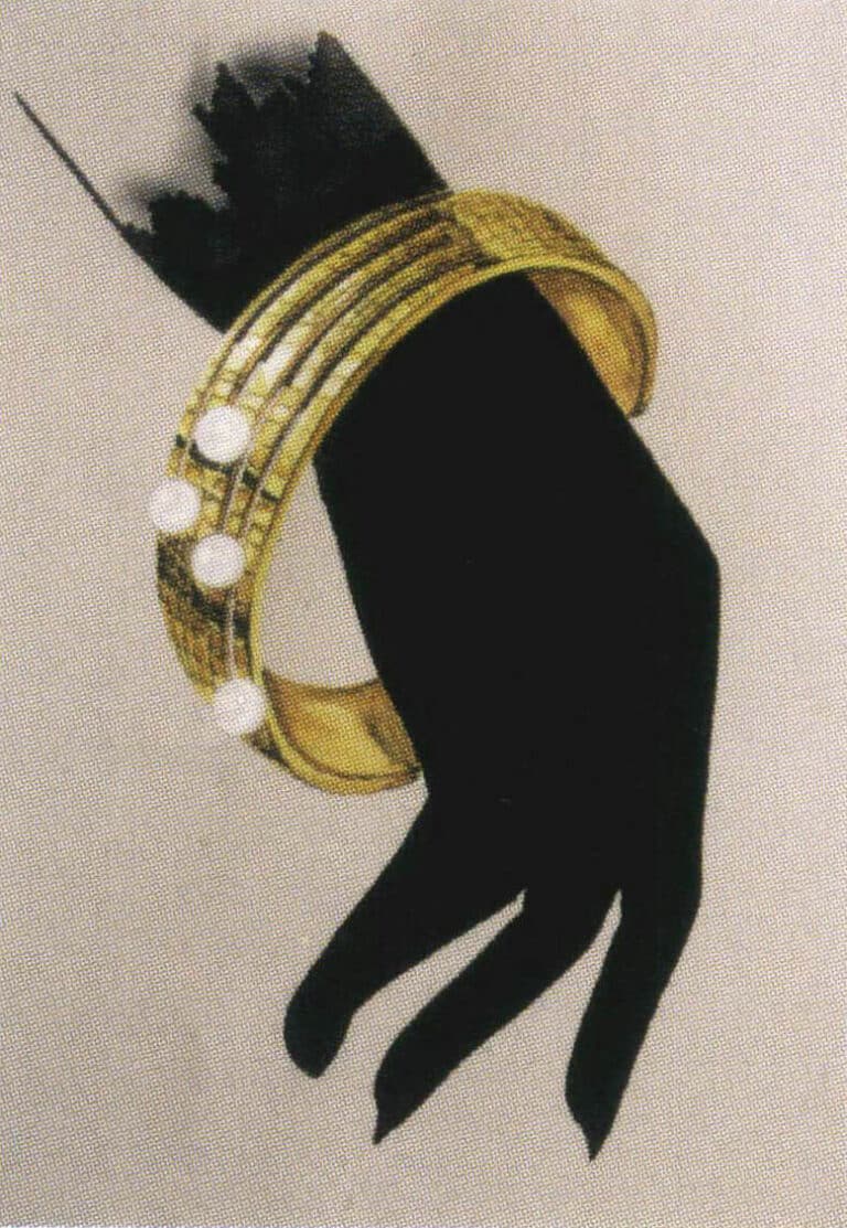 Η συνύφανση των μαύρων σχημάτων του χεριού όχι μόνο υποδεικνύει τη βασική θέση του κοσμήματος αλλά και συμπληρώνει τη λαμπερή λάμψη του χρυσού.