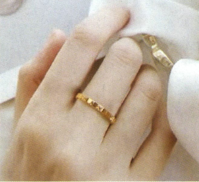 The same hand wearing a silver ring (left) and a gold ring (right)
