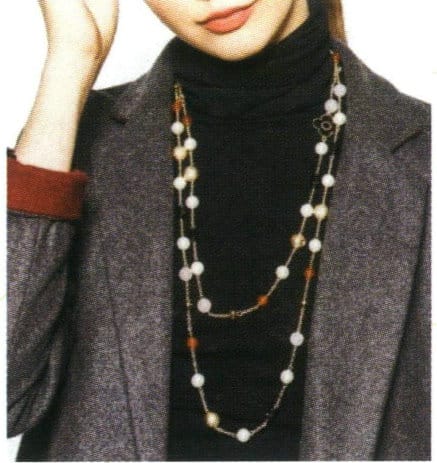 A plastic bead necklace is paired with a black sweater.