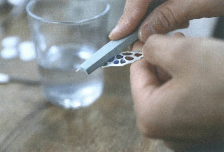 Figure 7–43 Filing an plique-à-jour enamel piece with a polishing oil stone