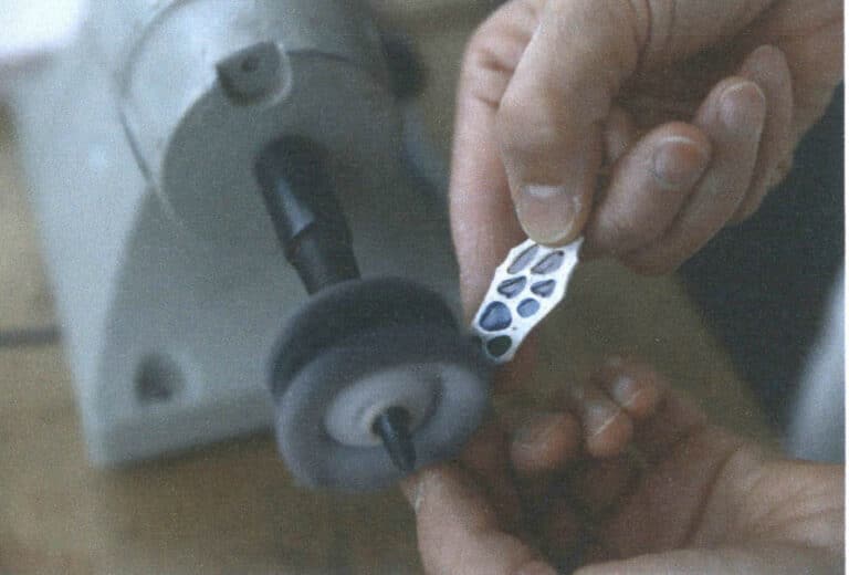 Figure 7–44 Polishing an plique-à-jour enamel piece with a polishing machine and cloth polishing wheel