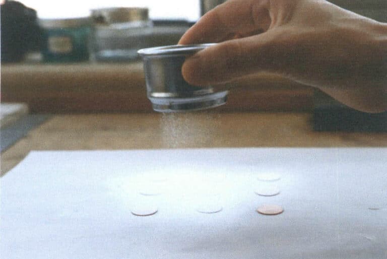 Figure 9-1 Sieving a base glaze onto multiple colour test plates using the dry sieving method