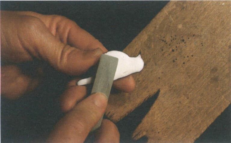 Figure 9–33 Grinding the porcelain-white ground glaze with an polishing oil stone