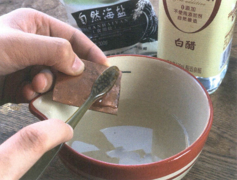 Figure 2–31 Cleaning a red copper base plate with white vinegar and salt